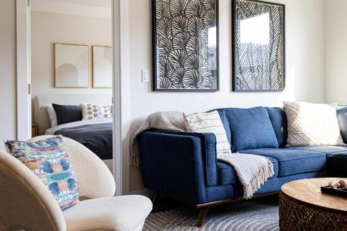a living room with a blue couch and a bed at Riverstone Retreat in Golden BC in Golden