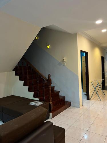 a living room with a staircase and a couch at GL Homestay in Sibu