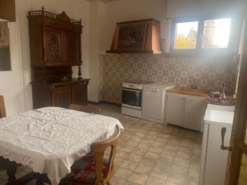 a kitchen with a table and a stove top oven at Maison Chez Grand-mère, Route des vins in Bergheim