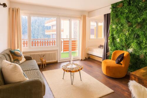 a living room with a couch and a table at Studio au Cœur des Sommets in Crans-Montana