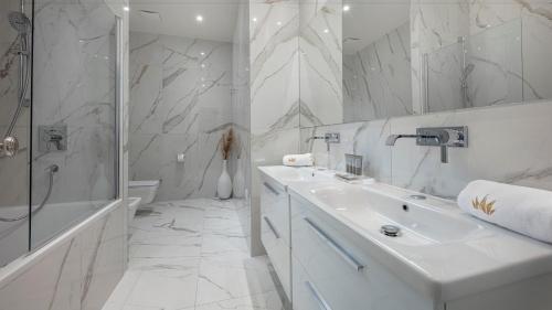 a white bathroom with a sink and a shower at Royal Neptun Hotel in Dubrovnik