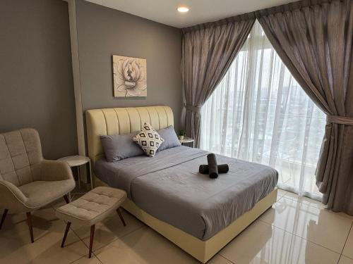 a bedroom with a bed and a chair and a window at JB City Shopping Mall Apartment in Johor Bahru