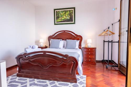 a bedroom with a large wooden bed and a dresser at Solar do Pico Studio in Ponta Delgada
