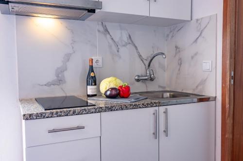 a kitchen counter with a sink and a bottle of wine at Solar do Pico Studio in Ponta Delgada