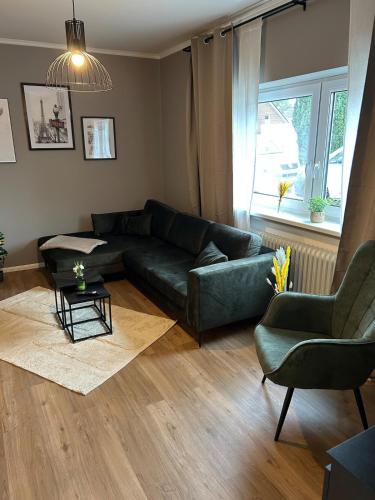 a living room with a green couch and a chair at Ferienwohnung Hodenhagen in Hodenhagen