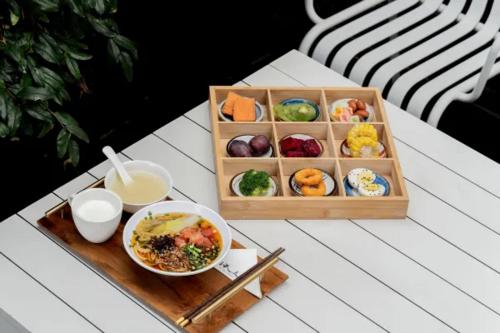 una bandeja de comida y un tazón de sopa en una mesa en Dali Ancient City Xishan Designer Hotel, en Antigua Ciudad de Dali
