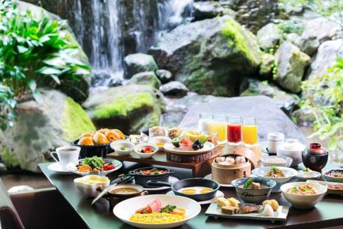 a table with plates of food and a waterfall at Hotel New Nagasaki in Nagasaki