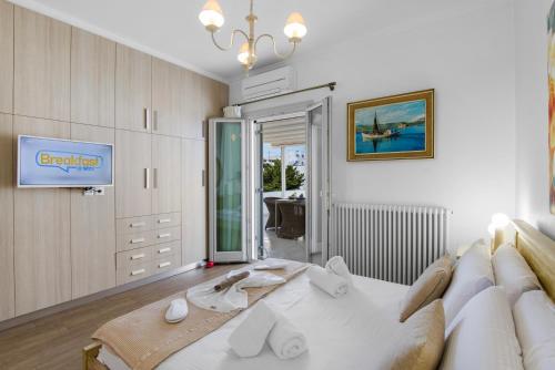 a living room with a white couch and a tv at Panos Apartment Naousa in Naousa