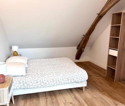 Un dormitorio con una cama y una estantería. en Maison avec grand jardin en centre ville, en Le Blanc