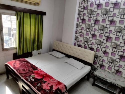 a bedroom with a bed with a green curtain at Shree Krishna Hotel in Udaipur