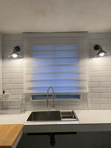 a kitchen with a sink and a window at BB Homestay in Tuaran