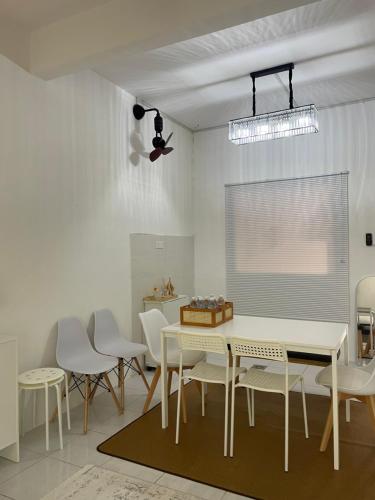 a dining room with a white table and chairs at BB Homestay in Tuaran