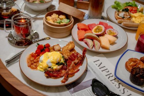 Una mesa con platos de comida para el desayuno. en Four Points by Sheraton Bangkok, Sukhumvit 22, en Bangkok