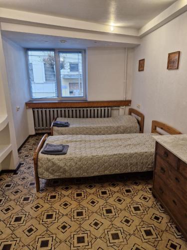 a bedroom with two beds and a window at Apartament Erfolg 6 in Daugavpils