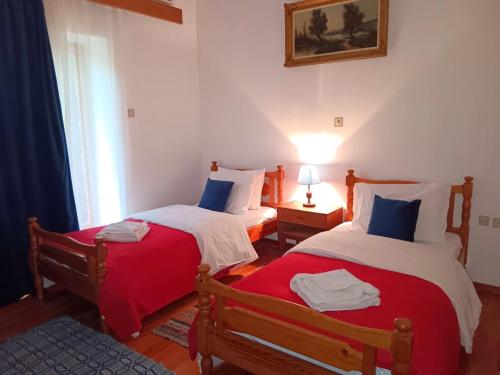 a bedroom with two beds with red and white at Cleopatrahouse in Stemnitsa