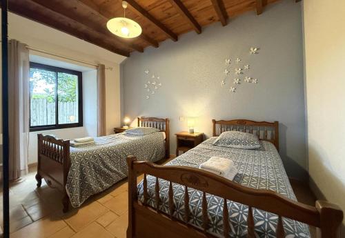 een slaapkamer met twee bedden en een raam bij Marty in Rébénacq