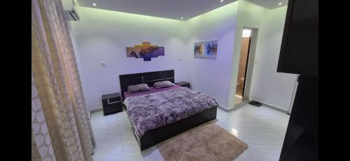 a bedroom with a bed with a purple blanket at Thiam APPART in Nouakchott