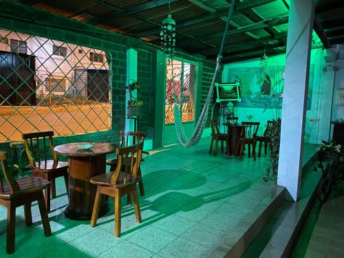 a room with a table and chairs and a swing at Hostal La Cabaña Típica in Playas