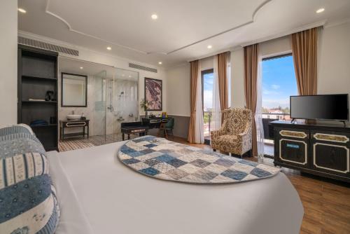 a hotel room with a bed and a television at JM Hoi An Beach Hotel - Free Shuttle Car To Old Town in Hoi An