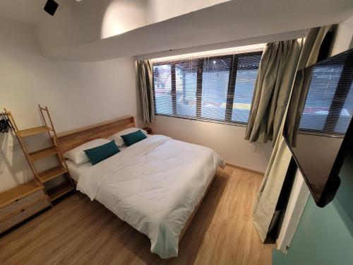 a small bedroom with a bed and a window at Nomad Shophouse in Kuala Lumpur