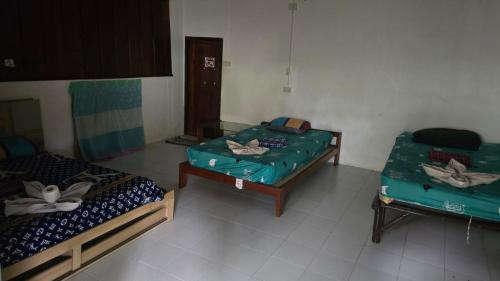 a room with two beds and a chair in it at Sunny hostel in Pai