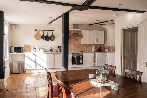 テュークスベリーにあるTysoes Court Tewkesburyのキッチン(木製テーブル、椅子、テーブル席付)