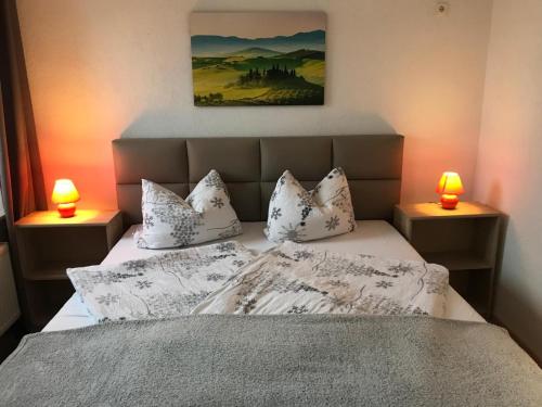 a bedroom with a bed with pillows and two lamps at Bergapartments in Kurort Oberwiesenthal
