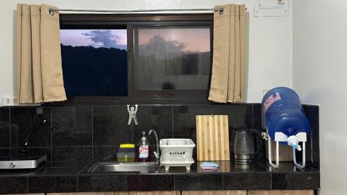 un comptoir de cuisine avec un évier et une fenêtre dans l'établissement Casa Ngato an Overlooking View Apartment in Baguio, à Baguio