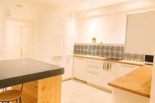 a kitchen with white cabinets and a black counter top at Appartement 4 Chambres proche commodités Ideal grande Famille et Groupe de professionnels Proche Paris in Puteaux