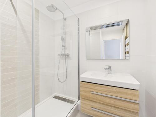 ein weißes Badezimmer mit Waschbecken und Dusche in der Unterkunft Maison en résidence - piscine - 2 adultes 2 enfants in Le Croisic