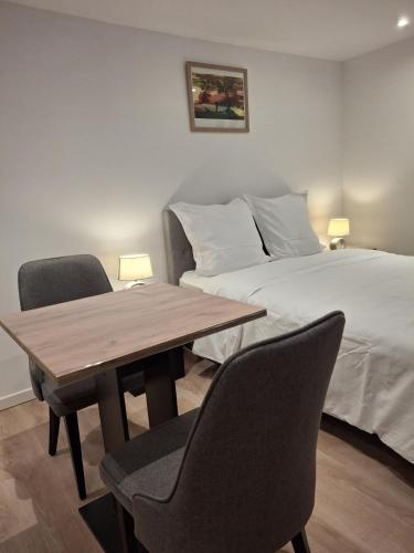 a bedroom with a bed and a wooden table and chairs at Studio dans centre historique in Vallauris