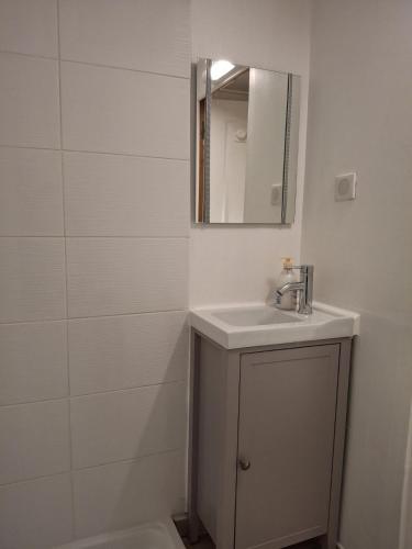 a white bathroom with a sink and a mirror at Studio dans centre historique in Vallauris