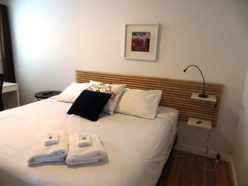 a bedroom with a bed with two towels on it at The Inn on College in Saskatoon