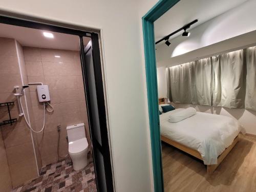 a bathroom with a bed and a shower and a toilet at Nomad Shophouse in Kuala Lumpur