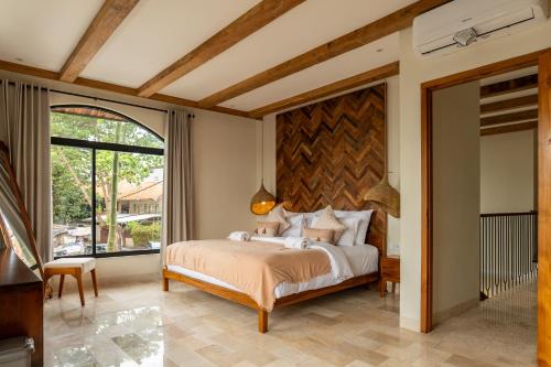 a bedroom with a bed and a large window at Tuluscoliving Villa Kuta 1, 4 Bedroom & 5 Bathroom in Ngurah Rai International Airport