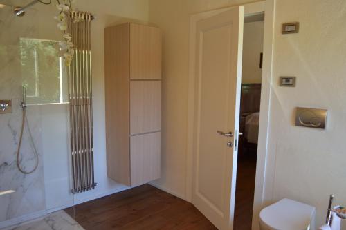 a bathroom with a shower and a toilet and a door at Casale La Rocchetta in Lonigo