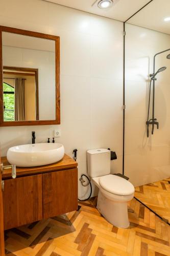 a bathroom with a toilet and a sink and a mirror at Tuluscoliving Villa Kuta 1, 4 Bedroom & 5 Bathroom in Ngurah Rai International Airport