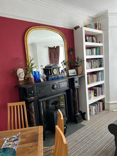 a living room with a fireplace and a mirror at Donnington Guesthouse in Truro