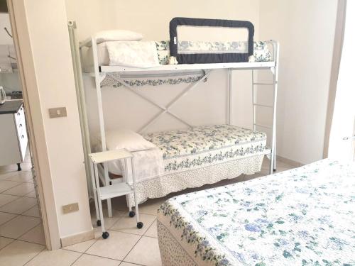 a room with two bunk beds and a chair at Ancora: appartamenti Gaudenzi in Gabicce Mare