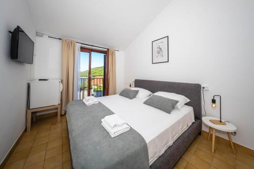 a bedroom with a large bed and a television at Room accomodation Jezera Lovišća in Jezera