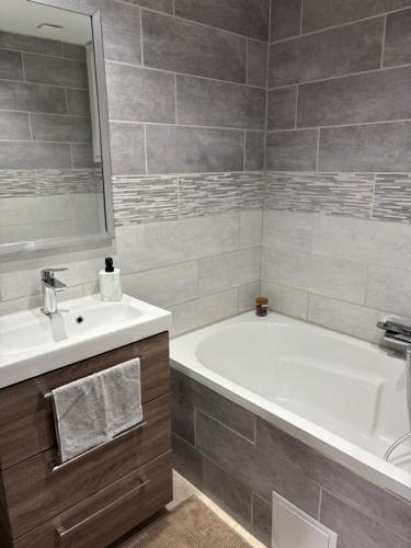 a bathroom with a white tub and a sink at Maison à la montagne in Castanet-le-Haut