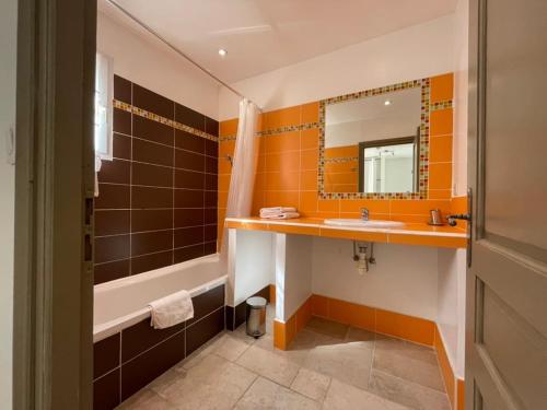 a bathroom with a tub and a sink and a mirror at Villa Verdi in Montauroux