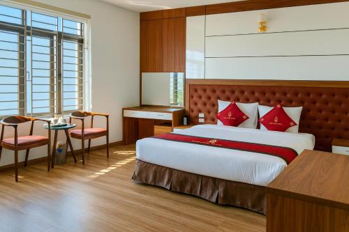 a bedroom with a large bed with red pillows at Bình Long II Hotel in Lai Châu