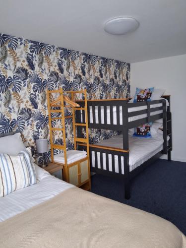 a bedroom with two bunk beds and blue and white wallpaper at Barbican Paignton in Paignton
