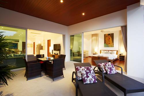 a living room with a dining table and a bedroom at 3BR SeaView Villa with Private Pool Kamala Falls in Kamala Beach