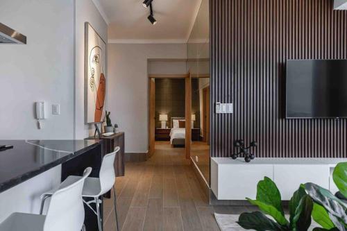 a living room with a television on a wall at ®{LUX~City~Skyline} @DowntownSD PrivéJaccuziGym in La Julia