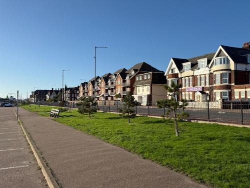 a row of houses on a street with a park at majestic hotel in Great Yarmouth