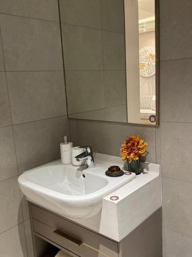 a white sink in a bathroom with a mirror at KL Desa Park City Muji Suite in Kuala Lumpur