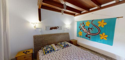 a bedroom with a bed and a painting on the wall at L'Oasis de L'Anse Bleue in Le Diamant
