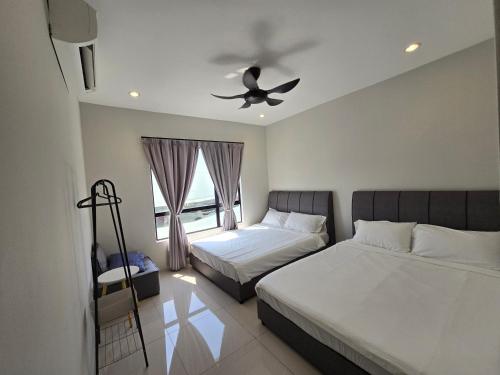 een slaapkamer met twee bedden en een plafondventilator bij Manhattan Condo - Ipoh Merveille Luxe Stay in Ipoh